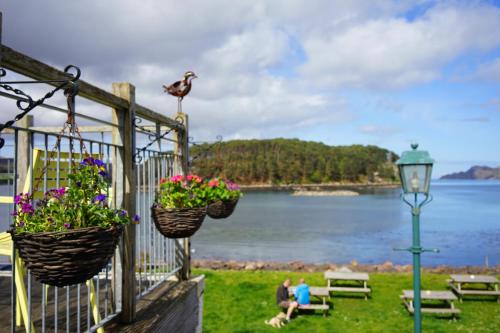 a fence with baskets of flowers and a street light at Tigh an Eilean Hotel in Shieldaig