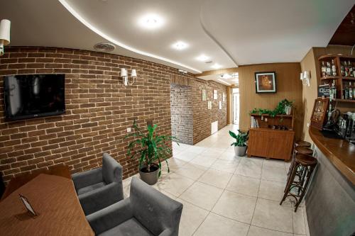 a restaurant with a brick wall and a table and chairs at Kolobok in Luts'k