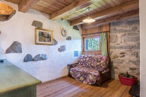 a living room with a chair and a window at Baita dai Cotai in Groppe de Fora