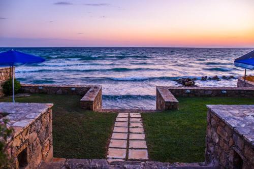 a pathway leading to the ocean at sunset at Betsis Apartments in Kipseli