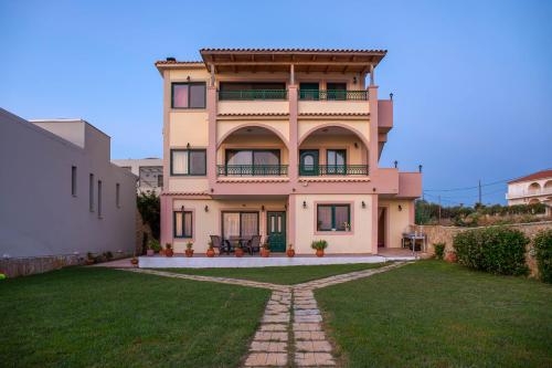 a large house with a green yard in front of it at Betsis Apartments in Kipseli