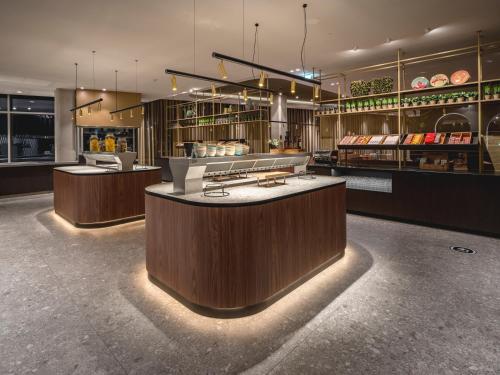 a restaurant with a counter in the middle at Van der Valk Hotel Amsterdam Zuidas -Rai in Amsterdam