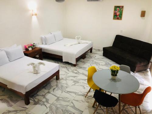 um quarto com duas camas, um sofá e uma mesa em Los Arcos Hotel - TULUM em Tulum