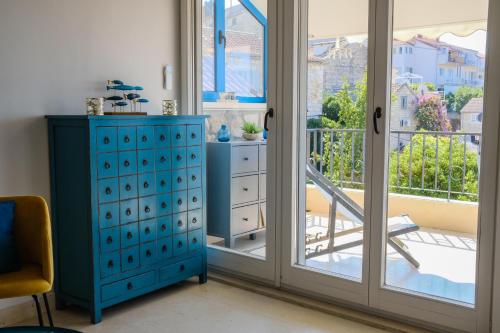 a bedroom with a blue dresser and a sliding glass door at Penthouse in old Dalmatian house - Flybridge in Hvar