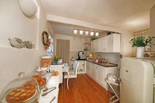 cocina con armarios blancos y nevera blanca en B&B Sant'Agostino, en Mondovì