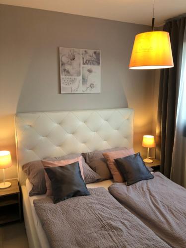 een slaapkamer met een bed met 2 kussens erop bij Szeged Gyöngye Lux in Szeged