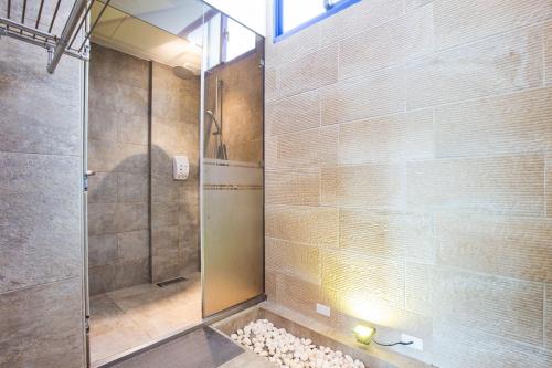 a shower with a glass door in a bathroom at 地中海海景包棟-無邊際泳池 家庭出遊 朋友聚會 生態體驗 推薦包棟首選 in Xiaoliuqiu