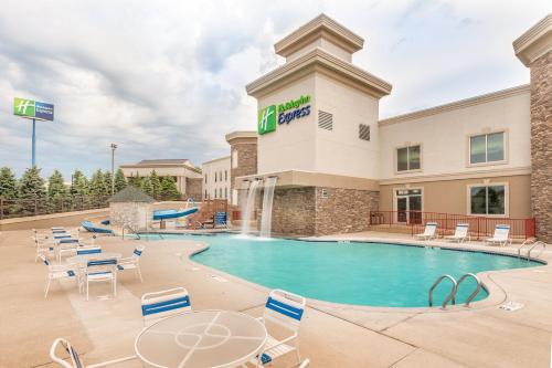 a pool at a hotel with chairs and tables at Holiday Inn Express Wisconsin Dells by IHG in Wisconsin Dells