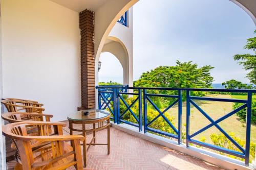 a room with a balcony with chairs and a table at 地中海海景包棟-無邊際泳池 家庭出遊 朋友聚會 生態體驗 推薦包棟首選 in Xiaoliuqiu