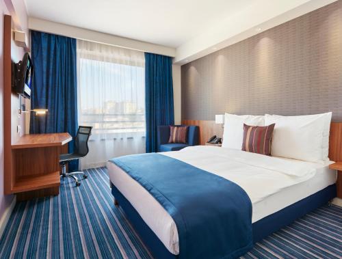 a hotel room with a large bed and a desk at Nobel Palace Hotel in Belgrade