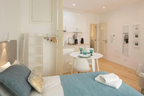 Cet appartement comprend une chambre avec un lit et une table ainsi qu'une cuisine. dans l'établissement Central Turquoise Studio, à Lisbonne