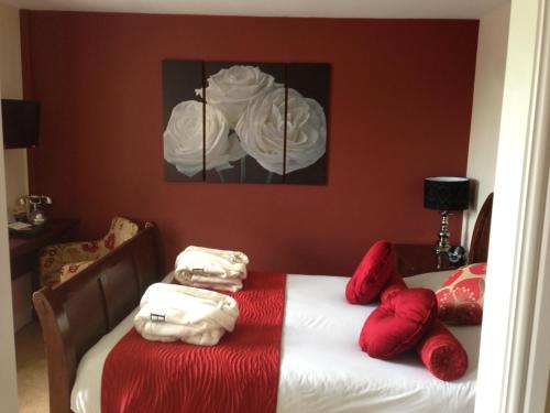 a bedroom with a bed with red and white towels at Bannatyne Hotel Darlington in Darlington