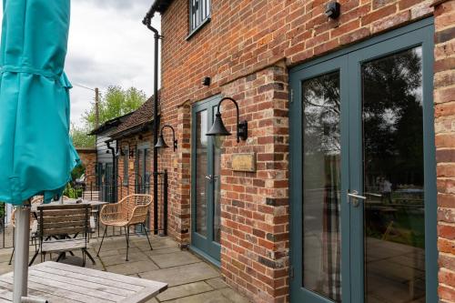 a brick house with a glass door and a patio at The Vineyard Lamberhurst in Lamberhurst