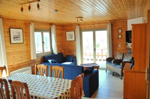 拉羅什－阿登的住宿－維納斯度假屋，客厅配有蓝色的沙发和桌子