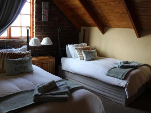 a bedroom with two beds with towels on them at Jocks Cottages in Dullstroom