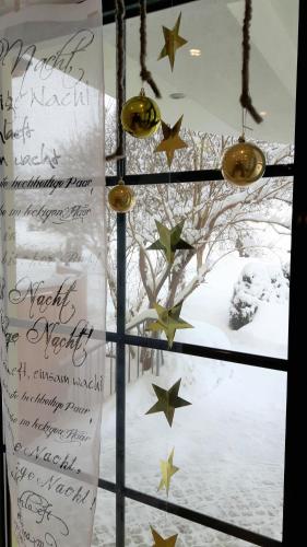 a window with christmas lights and stars at Landhotel Häuserl im Wald in Gröbming