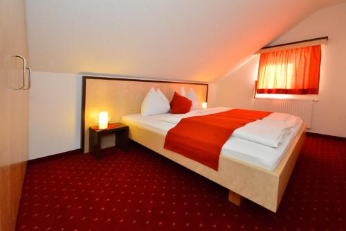 a bedroom with a large bed with a red carpet at Gasthof Wunder in Gnesau Sonnleiten