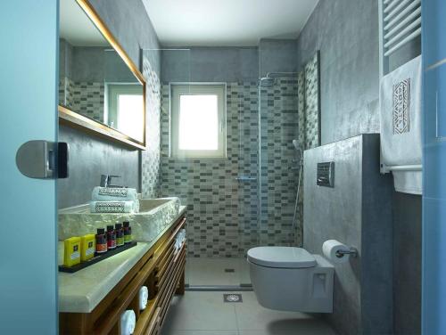 a bathroom with a sink and a toilet in it at Deluxe Crete Villa Villa Apoi 4 bedroom villa Private Pool Sea Views Chania in Chania
