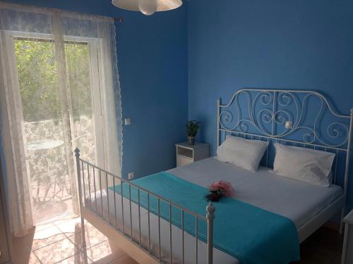 a blue bedroom with a bed and a window at Harmony in Kalamitsi