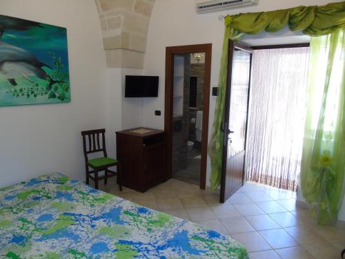 a bedroom with a bed and a chair and a door at Villa Tonia in Fasano