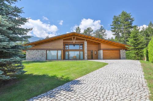 a house with a stone driveway in front of it at Pirin Golf & Country Club Apartment Complex in Bansko