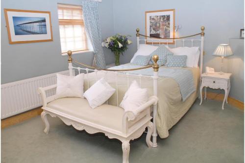 OYO The Leven في ستوكيسلي: غرفة نوم مع سرير مظلة مع كرسي أبيض