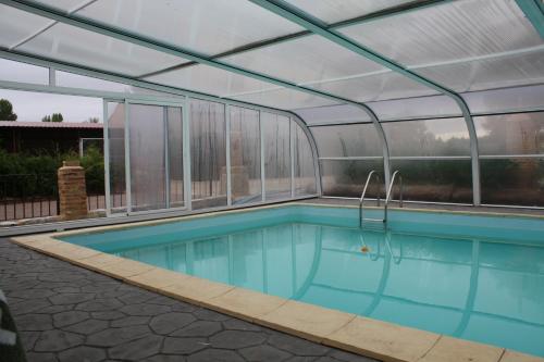 une piscine intérieure avec un toit en verre dans l'établissement El Jardin de la Huerta, à Sahagún