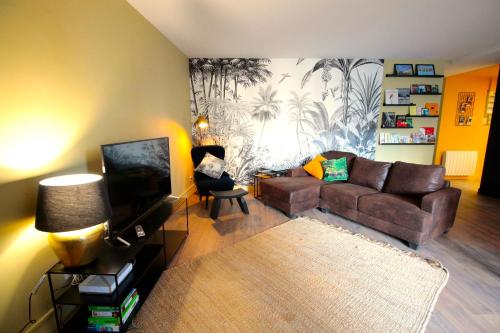 a living room with a couch and a tv at Mon Appart A GERLAND II in Lyon