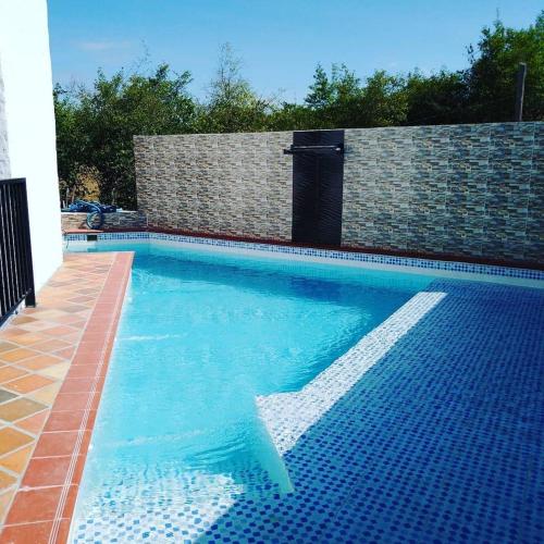 uma piscina com água azul e uma parede de tijolos em Cosmos Tatacoa Hotel em Villavieja