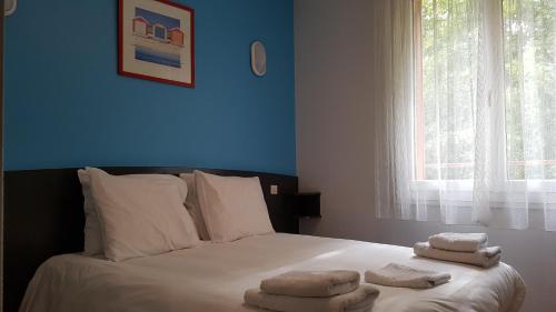 - une chambre avec un lit et des serviettes dans l'établissement Hotel Regina, à Ars-sur-Formans