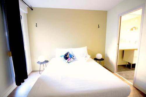 a bedroom with a large white bed and a mirror at Mon Appart A GERLAND II in Lyon