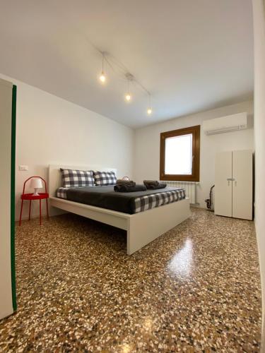 una camera con letto e sedia rossa di Ca' Berto Apartment a Venezia
