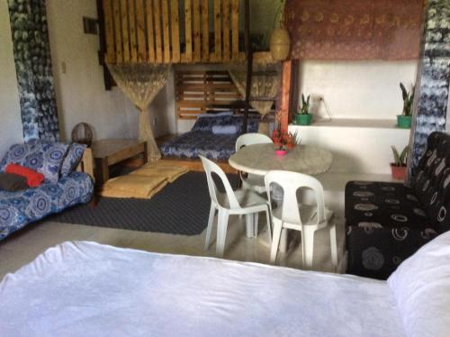 a bedroom with a bed and a table and chairs at Maraño's Home in Legazpi