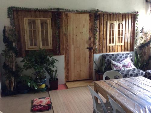a living room with a wooden door and a table at Maraño's Home in Legazpi