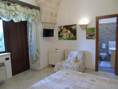 a bedroom with a bed and a chair and a window at Villa Tonia in Fasano