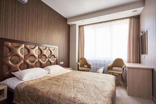 um quarto com uma cama grande e uma janela em Hotel Vladpoint em Vladivostok