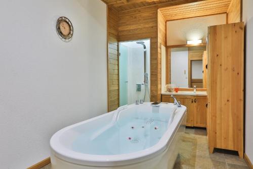 a large white tub in a bathroom with a sink at Pirin Golf & Country Club Apartment Complex in Bansko