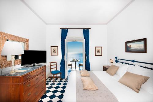 a living room with a bed and a tv at Grand Hotel Tritone in Praiano