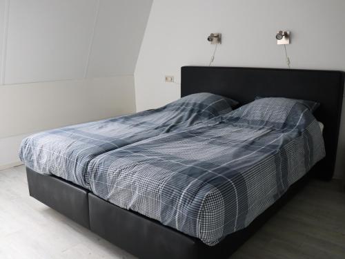 1 cama con manta de cuadros azul y blanco y 2 almohadas en DortDomburg, en Domburg
