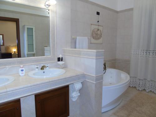 a bathroom with a tub and a sink and a bath tub at Villa Tonia in Fasano