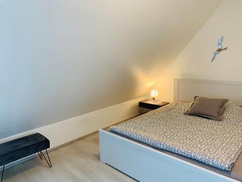 - une chambre avec un lit et une table de chevet dans l'établissement Ferienwohnung Syltliebe, à Wenningstedt