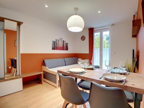 ein Esszimmer mit einem Tisch, Stühlen und einem Bett in der Unterkunft Stop Chez M Select Saga # Qualité # Confort # Simplicité in Saint-Fons