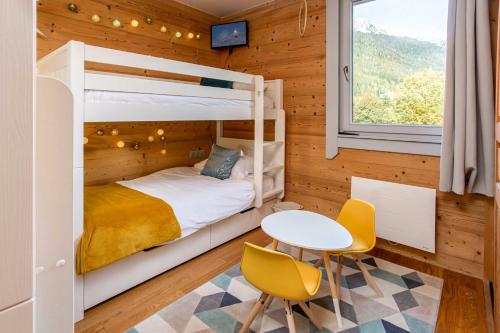 a bedroom with a bunk bed and a table and chairs at Le Paradis 25 Apartment - Chamonix All Year in Chamonix-Mont-Blanc