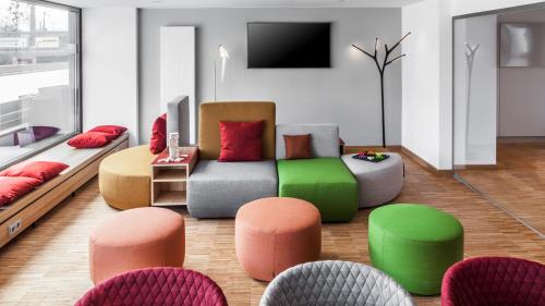 ein Wohnzimmer mit einem Sofa und einigen Stühlen in der Unterkunft Holiday Inn Munich - Leuchtenbergring, an IHG Hotel in München