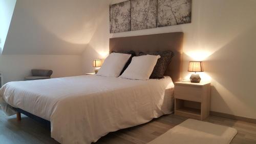 a bedroom with a large white bed with two lamps at La Pépite in Luchon
