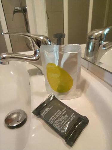 a bathroom sink with a toothbrush and a container of soap at Hostal Palas in A Coruña