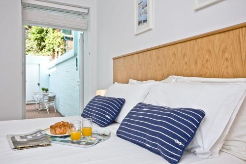 a bed with a tray of food and two glasses of orange juice at 3 Goodrington Lodge, Paignton in Paignton