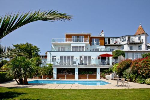 a large white building with a swimming pool in front of it at 3 Goodrington Lodge, Paignton in Paignton