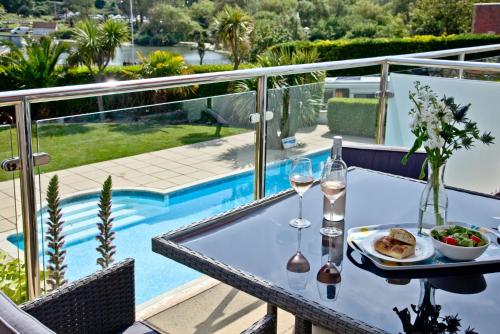 a table with a plate of food and wine glasses at 3 Goodrington Lodge, Paignton in Paignton