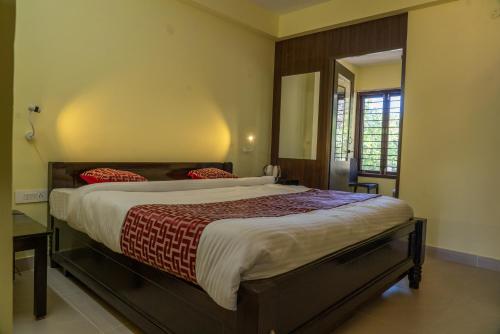 um quarto com uma cama grande e um espelho em VGR-HOMESTAY em Kodaikanal